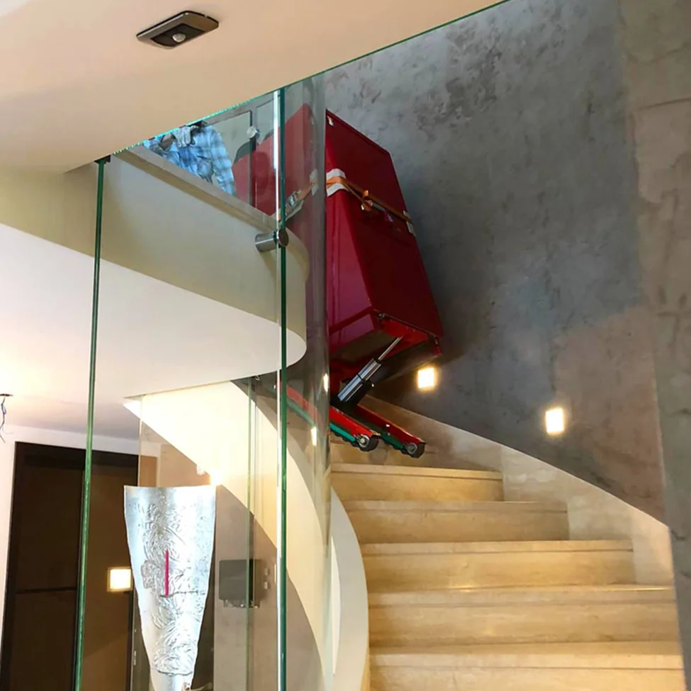 Transport d'un réfrigérateur lourd dans les escaliers avec le monte-escalier électrique