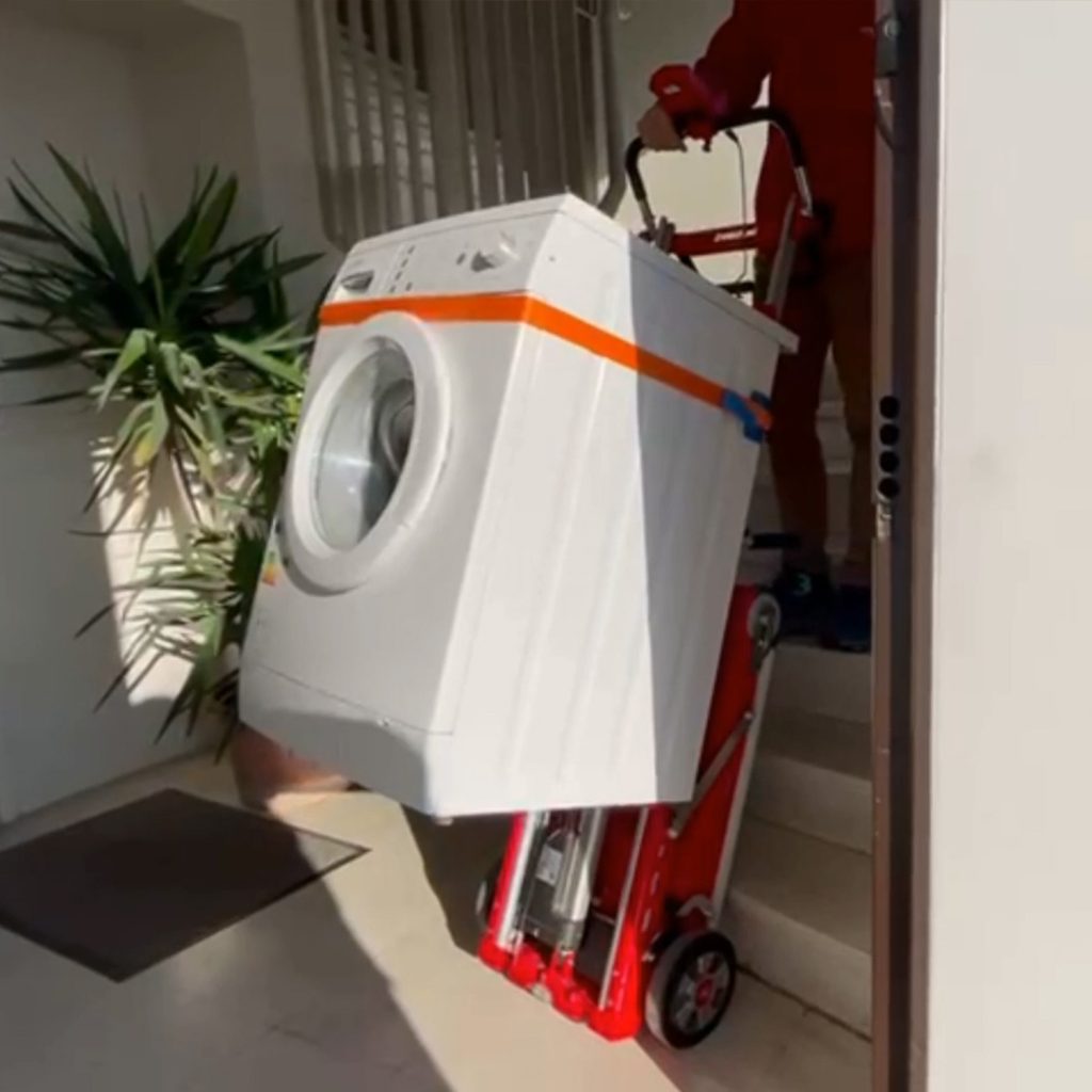 Transport d'un lave-linge sur un escalier avec le diable élévateur électrique Buddy.