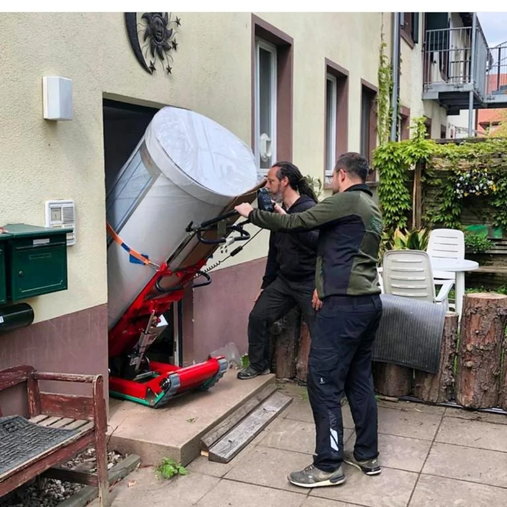 Transport d'une charge haute et lourde à travers la porte d'un bâtiment grâce au basculement automatique du chariot élévateur à chenilles Skipper Plasmoid